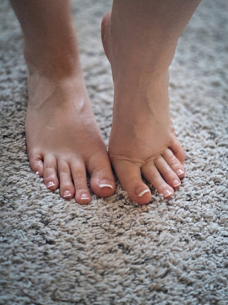 Top-down bare feet with French-tip pedicure on a soft rug — Barefoot Bunny, Dallas